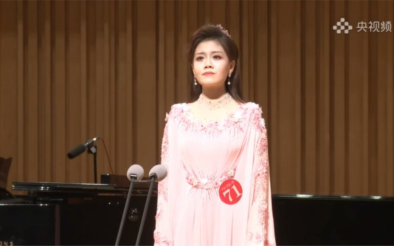 冯丽媛身着粉色礼服，站在音乐厅话筒前
