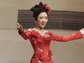 张群航身着红色礼服，举手演唱