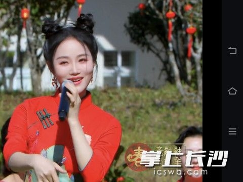 陈香水身着红色旗袍，在户外演唱