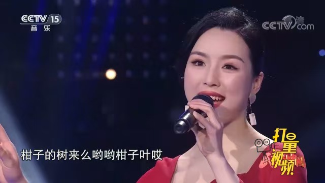 易文卉身着红色礼服，手持话筒演唱